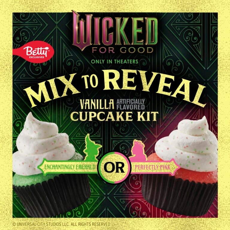 A promotional image for a Betty Crocker 'Wicked For Good' vanilla cupcake kit. The background is a dark green and black patterned texture. At the top, the 'Wicked For Good' logo is displayed in pink and green. Below it, large white text reads 'MIX TO REVEAL' and smaller text says 'VANILLA ARTIFICIALLY FLAVORED CUPCAKE KIT'. Two cupcakes with white frosting are shown at the bottom. The cupcake on the left has green cake and is labeled 'ENCHANTINGLY EMERALD'. The cupcake on the right has pink cake and is labeled 'PERFECTLY PINK'. A yellow circle with 'OR' in the center is between the two cupcakes. The Betty Crocker logo is in the top left corner. The Universal City Studios LLC copyright is at the bottom.